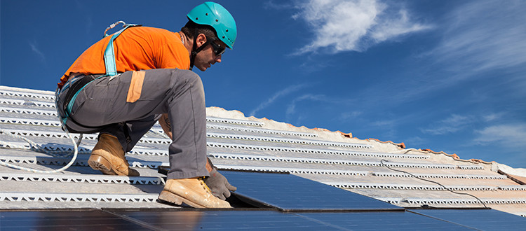 Guy putting in new solar panels on roof